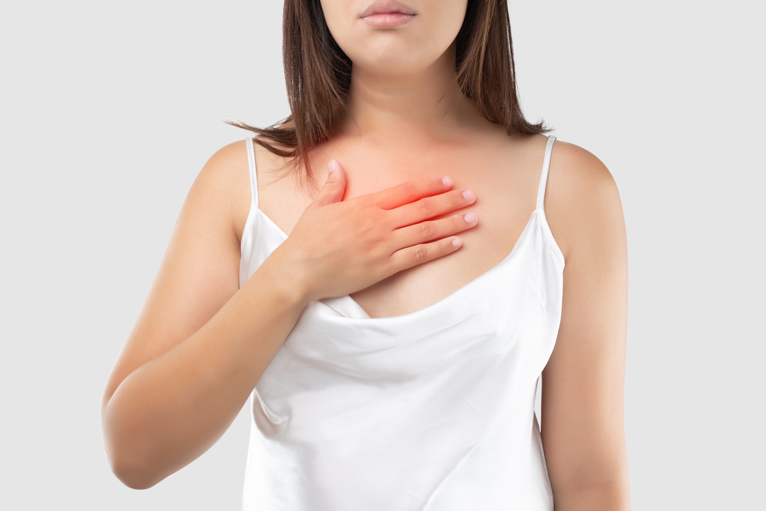 A woman suffering from acid reflux or heartburn on gray Background